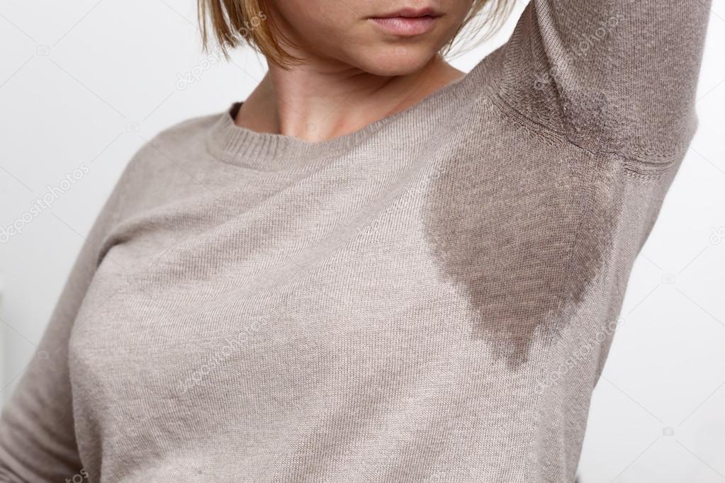 Young woman looking at the sweaty shirt