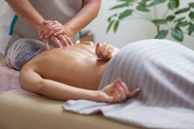 Beyaz kadın spa salonunda omurga masajı yaptırıyor.