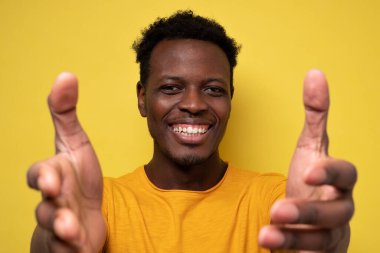 Sarı arka planda gülümseyen Afro-Amerikan bir adam. Olumlu yüz insani duygu.