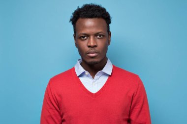 Yakışıklı, ciddi bir Afrikalı adam kameraya ciddi bir ifadeyle bakıyor.