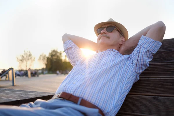 Homem sênior em óculos de sol relaxando em um parque — Fotografia de Stock