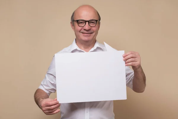 Hombre hispano mayor con gafas sosteniendo un cartel en blanco — Foto de Stock