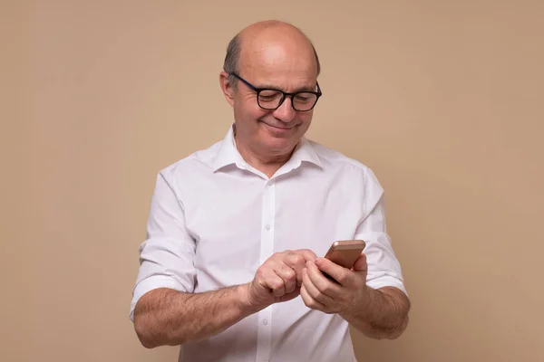 Ώριμος άνδρας που διαβάζει sms ή γραπτό μήνυμα στο κινητό του — Φωτογραφία Αρχείου