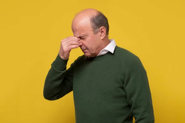 Gammal man vidrör näsan med handen, med slutna ögon, försöker koncentrera — Stockfoto