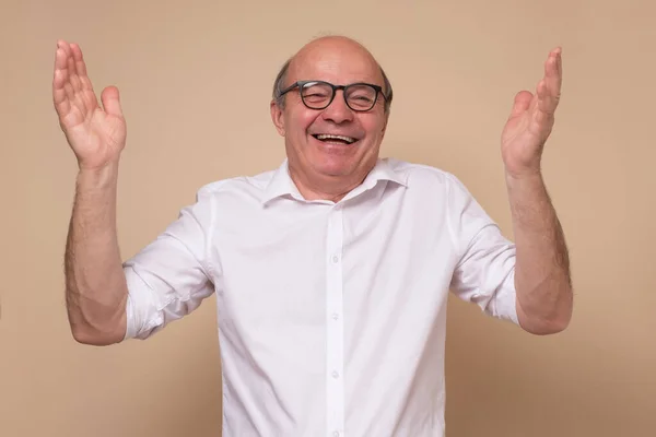 Älterer hispanischer Mann mit Brille lacht über Witz. — Stockfoto