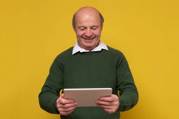 Элегантный лысый мужчина, уверенно улыбающийся в камеру, держа планшет — стоковое фото