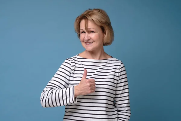 Senior caucasian woman approving doing positive gesture with hand, thumbs up — стокове фото