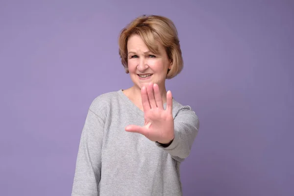 Mujer de mediana edad haciendo dejar de cantar con la palma de la mano mostrando cinco dedos. — Foto de Stock