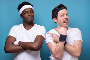 Gülümseyen iki arkadaş, Avrupalı ve Afrikalı adamlar kameradan emin görünüyorlar.