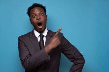 Şok olmuş Afrikalı bir adam ağzını açıp fotokopi alanını işaret ediyor.