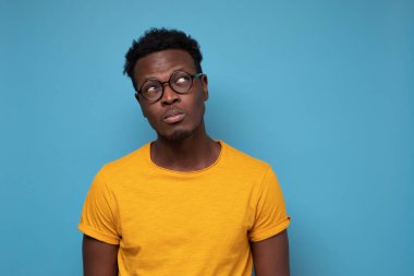 Afrikalı adam şüpheyle bakıyor, tereddütleri var, ne yapacağını düşünüyor.