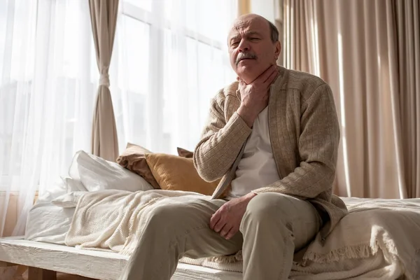 Starszy mężczyzna rasy kaukaskiej cierpiący na ból gardła. — Zdjęcie stockowe