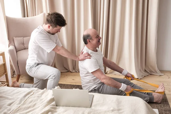 Treinador de ioga masculino ajuda ao homem sênior a fazer asana corretamente. — Fotografia de Stock