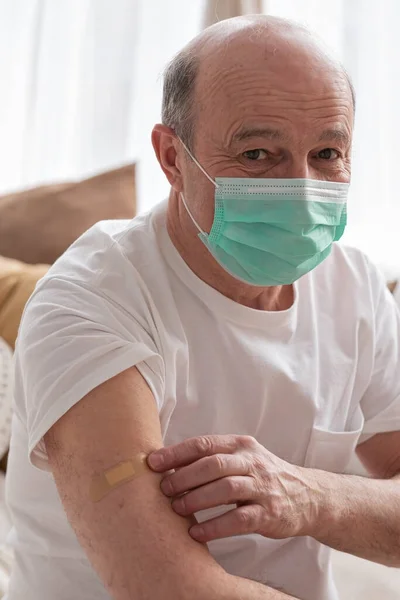 Старший латиноамериканец в маске, с вакцинированной рукой.. — стоковое фото