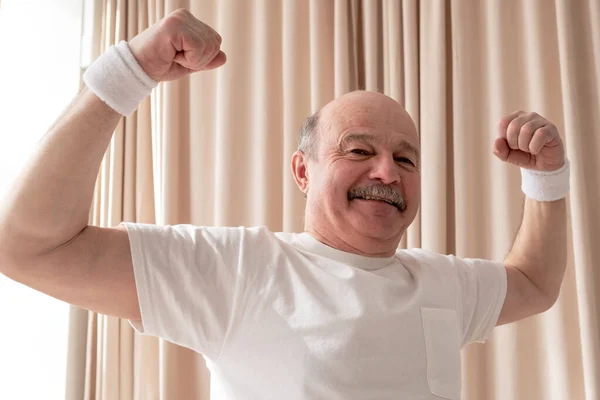 Starší muž ukazuje svaly být hrdý na své zdraví — Stock fotografie