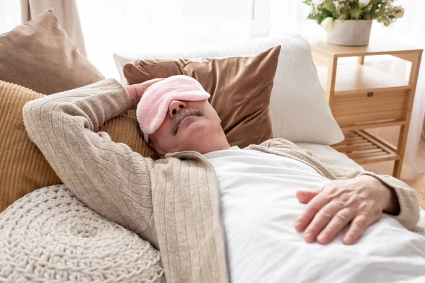 Sover senior man i sömn ögonmask på sängen. — Stockfoto