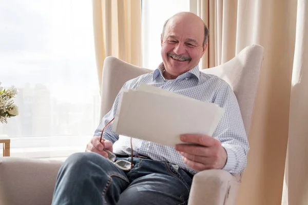Senior homem wathcing fotos de sua família sorrindo — Fotografia de Stock