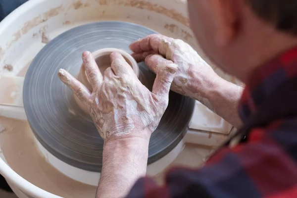 Roda de oleiro e mãos de artesão fazendo um jarro — Fotografia de Stock