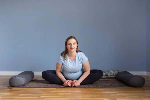 Pregnant woman doing morning yoga sitting in Baddha Konasana or Bound Angle — Stock Photo, Image