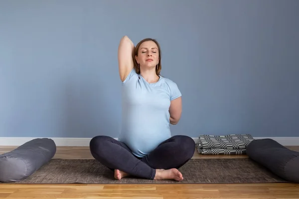 Yogada doğum öncesi yoga yapan hamile bir kadın ellerini ve göğsünü uzatarak poz veriyor.. — Stok fotoğraf
