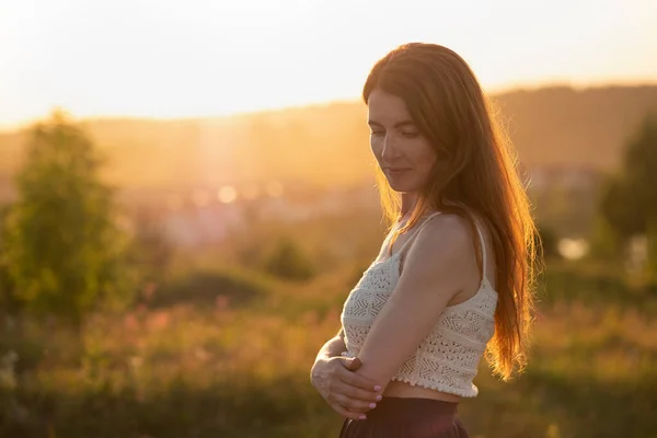 Mulher feliz sorrindo e olhando para baixo no campo de verão — Fotografia de Stock