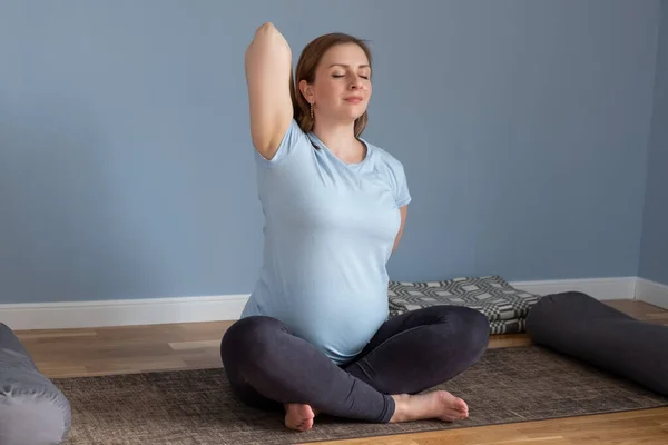 Yogada doğum öncesi yoga yapan hamile bir kadın ellerini ve göğsünü uzatarak poz veriyor.. — Stok fotoğraf