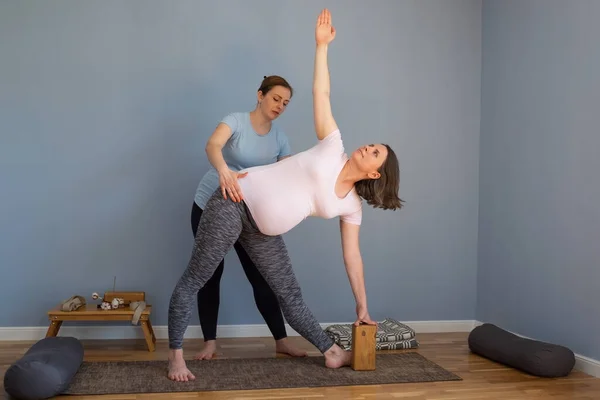 Hamilelik yoga modeli İndoo üzerinde çalışıyor Genişletilmiş Üçgen pozu veriyor. — Stok fotoğraf