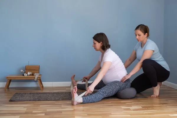 Hamile bir beyaz kadın oturuyor ve yoga yapıyor, yaslanıyor.. — Stok fotoğraf