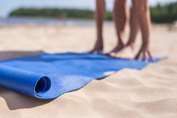 Güneşli bir günde kumsalda yoga yaparken kız.