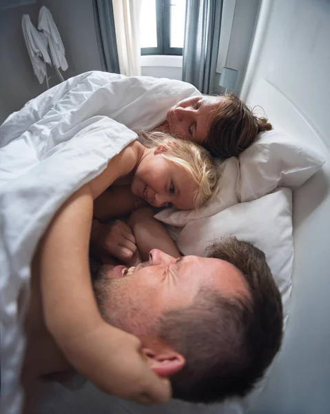 4 yaşındaki küçük bir kız sabah ailesini uyandırıyor ve uyumalarına izin vermiyor. Yüksek kalite fotoğraf