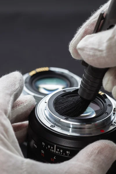 Man cleans the lens from accumulated dirt and dust — Stock Photo, Image