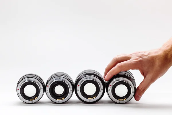 Man's hand adjusts a photographic lens. A collection of expensive toys for adults — Stock Photo, Image