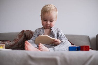 Küçük Yürüyen Kız Yatakta Oturuyor ve Bağımsız Oyuncaklarla Oynuyor. Yüksek kalite fotoğraf