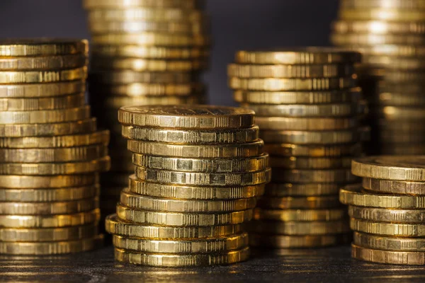 Montones de monedas de oro sobre fondo negro — Foto de Stock