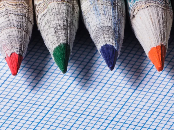 Цветные карандаши крупным планом на фоне графической бумаги — стоковое фото