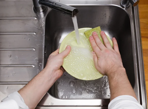 Man washing dishes without gloves — Stock Photo, Image