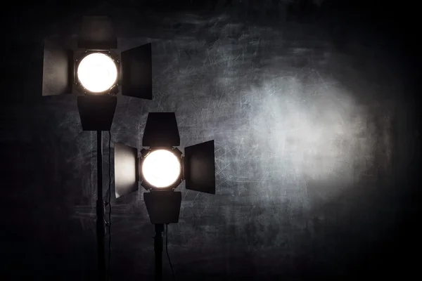 Equipo de iluminación sobre un fondo negro vieja pared de mala calidad —  Fotos de Stock