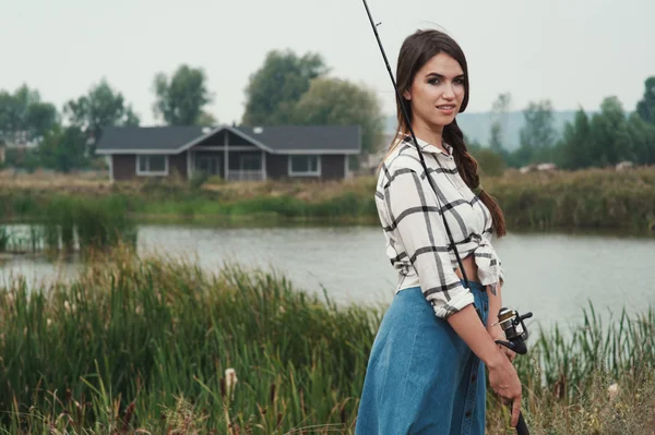 Señora del campo de pie contra el estanque en el rancho con caña de pescado —  Fotos de Stock