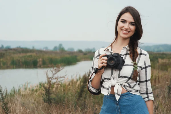Pretty playful country lady posing with camera against pond — Stock Photo, Image