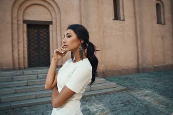 Dama en vestido contra edificio antiguo con mirada reflexiva —  Fotos de Stock