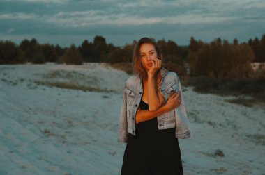 seksi sarışın saçlı genç kadın çöl kumları poz kırmızı ayar güneş ışığı tarafından yaktı