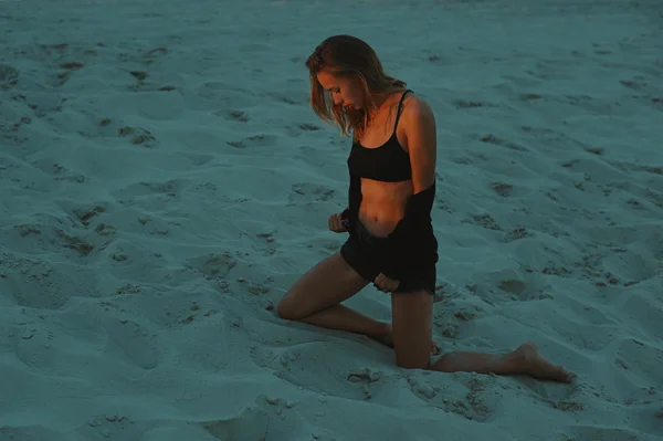 Sexy rubia pelo joven posando en arenas del desierto iluminado por la luz del sol poniente rojo — Foto de Stock