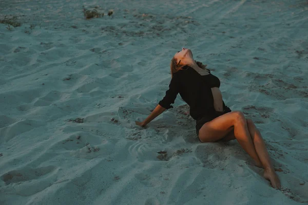 Sexy rubia pelo joven posando en arenas del desierto iluminado por la luz del sol poniente rojo — Foto de Stock