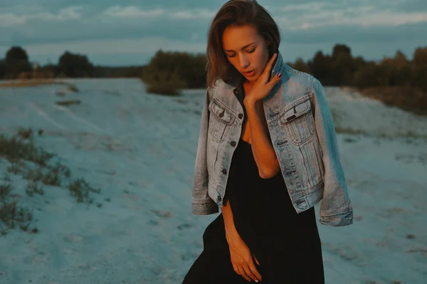 Sexy rubia pelo joven posando en arenas del desierto iluminado por la luz del sol poniente rojo — Foto de Stock