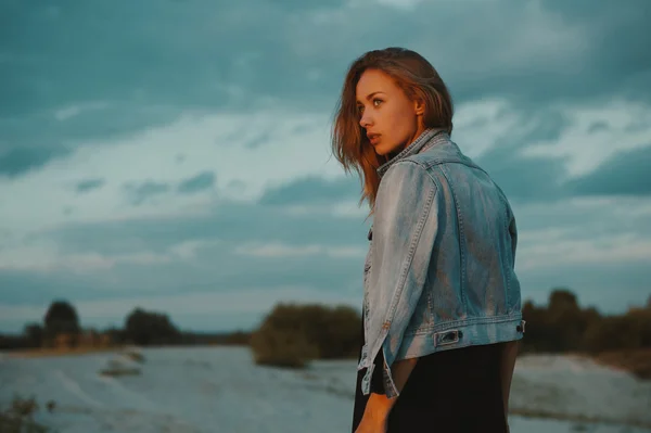 Sexy rubia pelo joven posando en arenas del desierto iluminado por la luz del sol poniente rojo — Foto de Stock