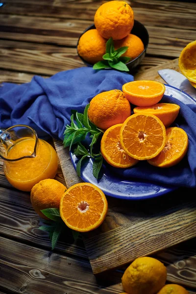 Vers Sinaasappelsap Sinaasappels Met Munt Tafel Met Blauwe Doek Mes Rechtenvrije Stockafbeeldingen