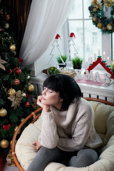 Smiling brunette sitting in the armchair — Stock Photo, Image