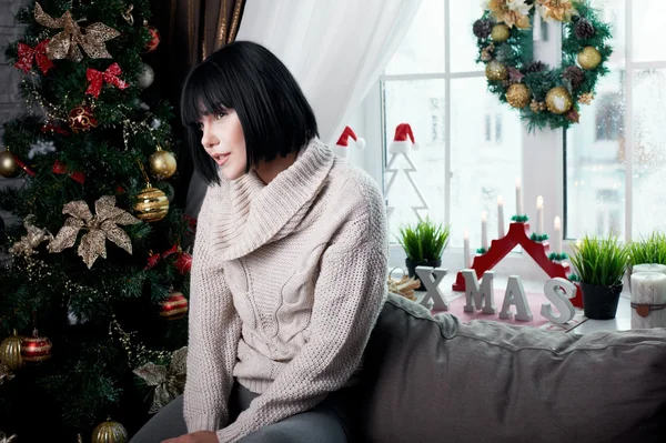 Brunette sitting on the couch — Stock Photo, Image