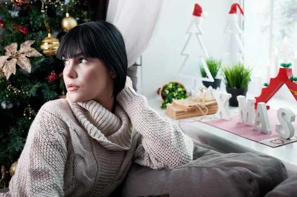 Brunette sitting on the couch — Stock Photo, Image