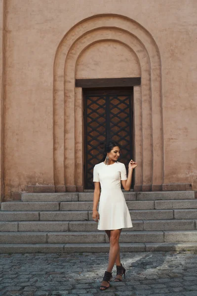 Flirta indisk dam i vit klänning mot gammal byggnad — Stockfoto